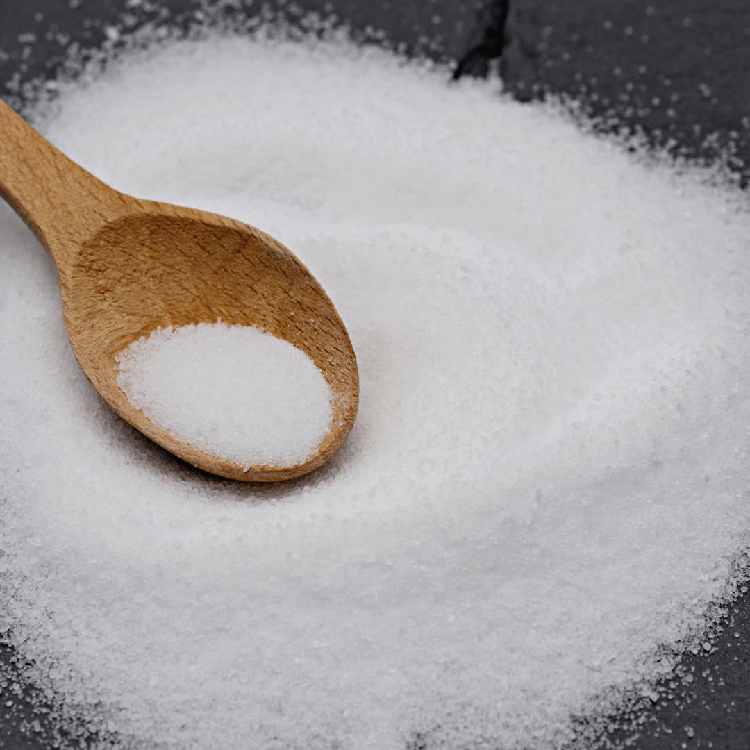A scoop of loose salt beside a feed tub